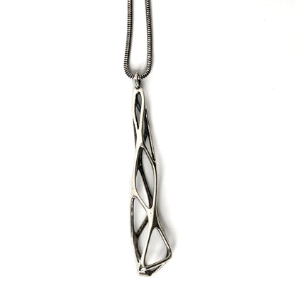 The contrast oxidized solid sterling silver "Tamarix" pendant is photographed on a white background. The outer surfaces are polished to a mirror shine. The inner surfaces of this delicate lattice are contrast oxidized for a dark matte finish. The twisting lattice is suspended from a matching snake chain. 