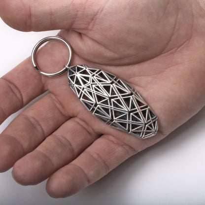 Sterling silver keychain with detailed geometric latticework designed to fit comfortably in the hand. 