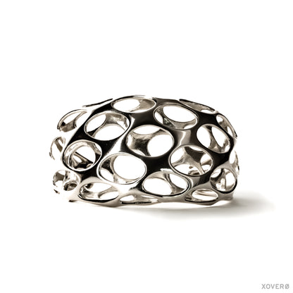 A tall chunky double layered cuff bracelet in sterling silver with a bold pattern of rounded cutouts. 