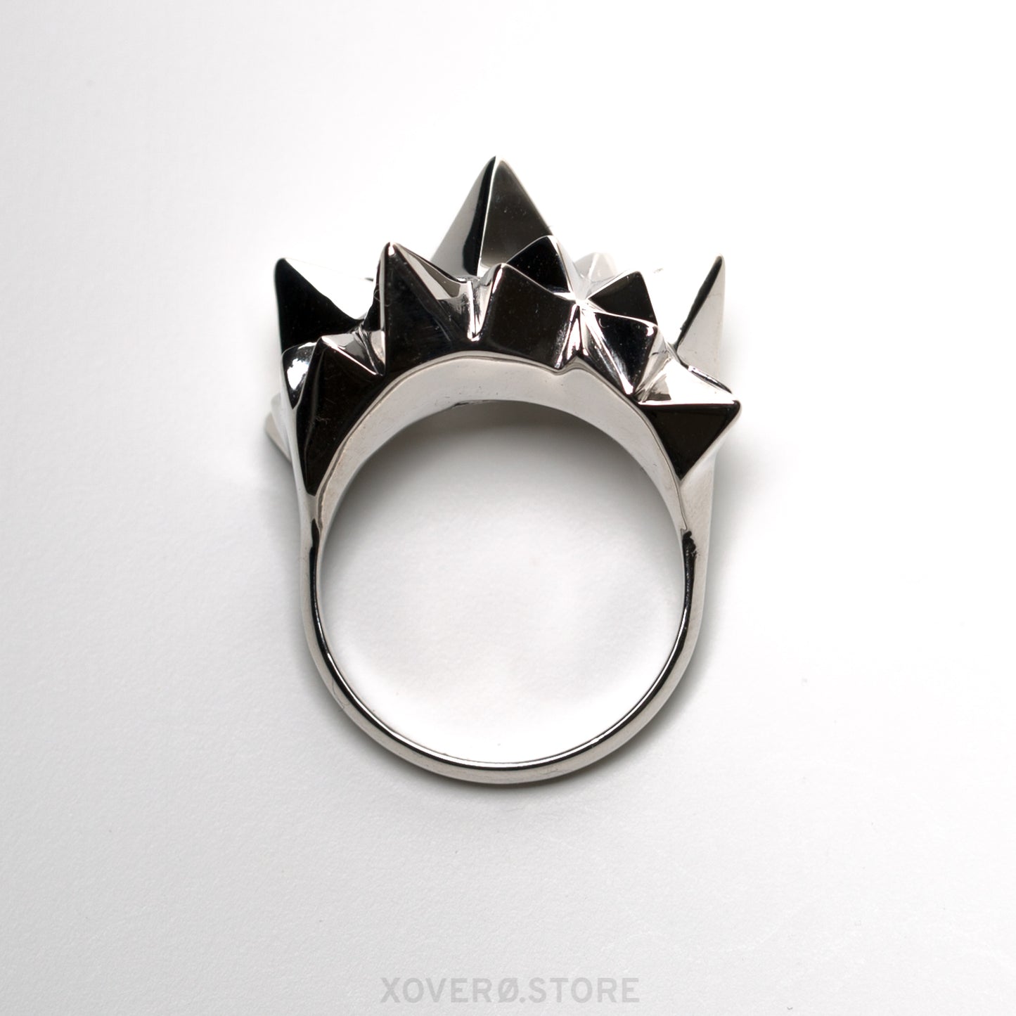 Front view of a cocktail ring crowned with dimensional spikes in solid sterling silver. The mirror polished finish reflects light and shadow in dramatic contrast. 