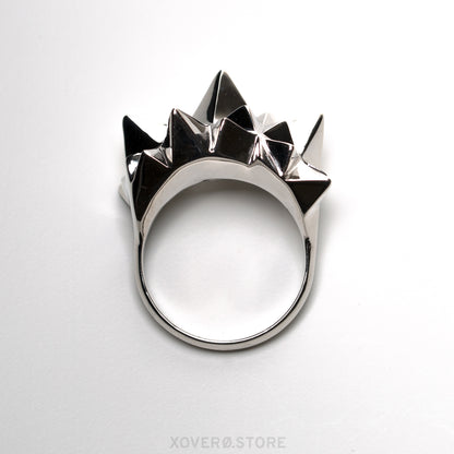 Front view of a cocktail ring crowned with dimensional spikes in solid sterling silver. The mirror polished finish reflects light and shadow in dramatic contrast. 